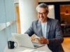 Mann vor Laptop und Smartphone