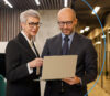 Mann und Frau schauen gemeinsam im Büro auf einen Laptop
